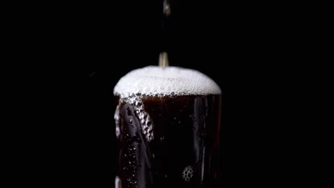 Pouring Hot Tea, Drink, or Whiskey into a Wet Glass on a Black Background Stock Footage 262758445