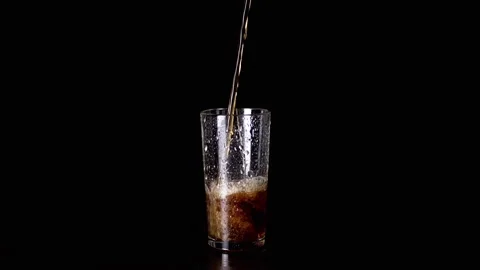 Pouring Hot Tea, Drink, or Whiskey into a Wet Glass on a Black Background Stock Footage 263642664