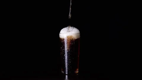 Pouring Hot Tea, Drink, or Whiskey into a Wet Glass on a Black Background Stock Footage 263791384