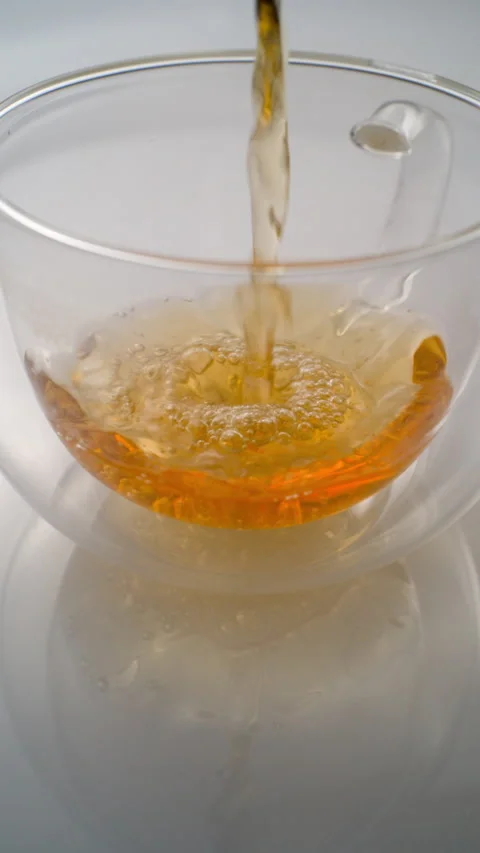 Pouring Hot Tea or Herbal Infusion into a Glass Mug Stock Footage 320358199