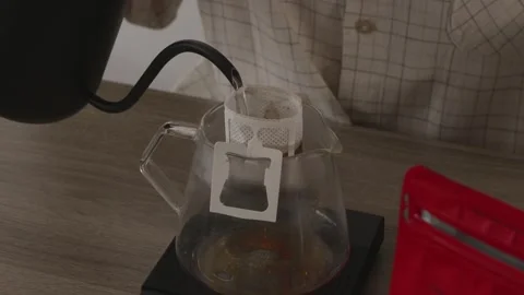 Pouring hot water into drip coffee filter bag on a cup Stock Footage 335143401