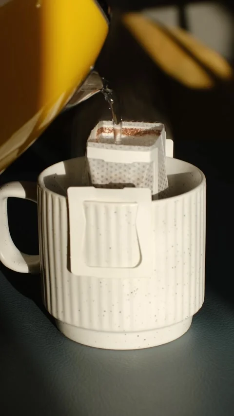 Pouring hot water into drip coffee bag in mug Stock Footage 337545801