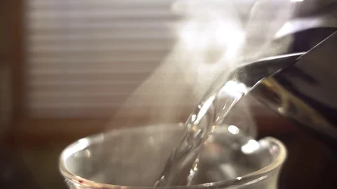 Pouring hot water in glass tea and coffee server. Closeup, slow motion. Stock Footage