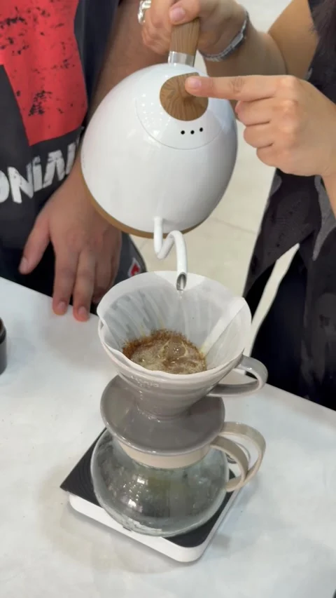 Pouring hot water from kettle into drip coffee maker, vertical view Stock Footage 345158880