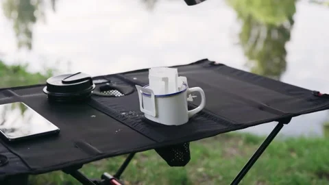 Pouring hot water through drip coffee bag outdoors Stock Footage 194538792