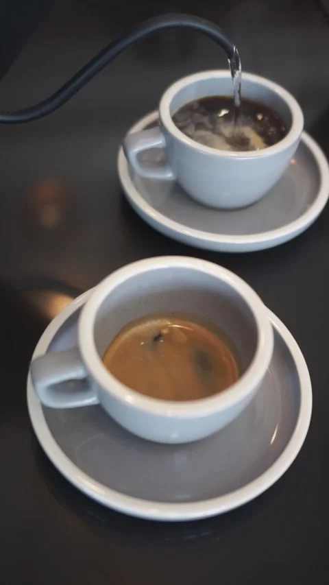 Pouring hot water into two cups to make hot drinks Stock Footage 310747357