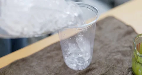 Pouring ice cube into a plastic glass. Stock Footage 183846057