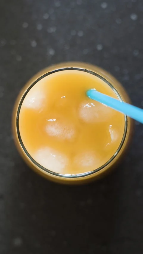 Pouring ice cubes into glass cup with juice in slow motion Stock Footage 342239318