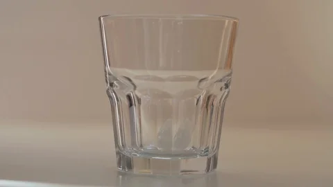 Pouring ice into the empty glass in slow motion Stock Footage 126835813