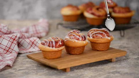 Pouring icing over swirl buns with jam. Stock Footage 128738062