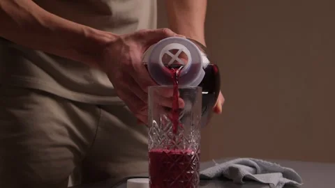 Pouring juice quickly. Closeup of hands pouring bright red juice into glass Stock Footage 346244266