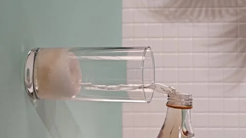 Pouring lemonade into a glass while bubbles and gases form on the surface Stock Footage 339592740