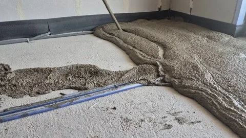 Pouring lightweight polystyrene concrete over heating pipes slow motion Stock Footage 341510059