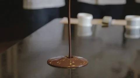 Pouring liquid chocolate onto table Stock Footage 229718610