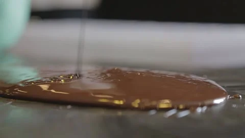 Pouring liquid chocolate onto table Stock Footage 229718623