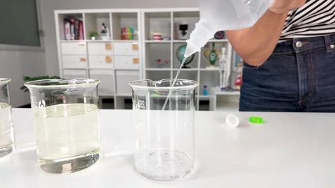Pouring Liquid into Glass Beaker for Science Experiment in Laboratory Stock Footage 346012897