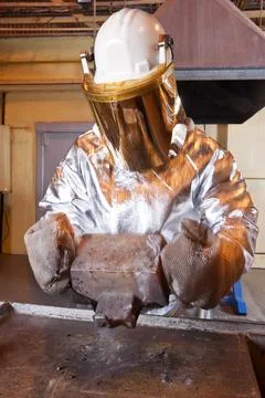 Pouring liquid gold into graphite casting form from furnace Stock Photos