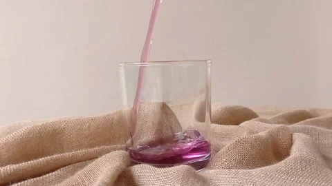 Pouring liquid of grape jelly into a small bowl Stock Footage 146253849