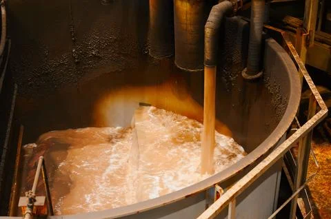 Pouring liquid into huge bath of modern floatation machine Stock Photos