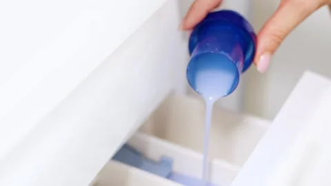Pouring liquid laundry detergent or fabric softener in washing machine Видео 331458784