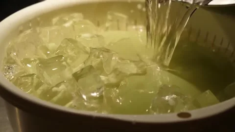 Pouring Liquid Over Ice Cubes in Bowl Video stock 347689453