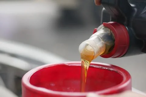 Pouring Liquid Into Red Funnel For Engine Maintenance 스톡 사진