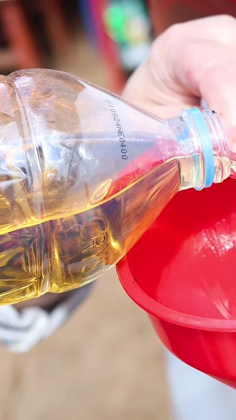 Pouring Liquid into a Red Funnel Stock Footage 305535397