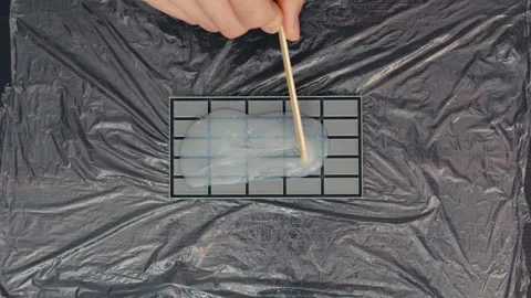 Pouring Liquid Silicone into 3D Printed Molds: Craftsmanship Close-up, Top View Stock Footage 251175979