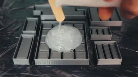 Pouring Liquid Silicone into 3D Printed Molds: Craftsmanship Close-up, Top View Stock Footage 256027185