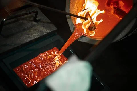 Pouring liquid silver into casting form with metal tool Stock Photos