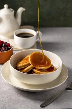 Pouring maple syrup over stack of homemade pancakes Stock Photos
