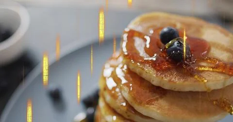 Pouring maple syrup over stack of golden pancakes on matte gray plate on Stock Photos