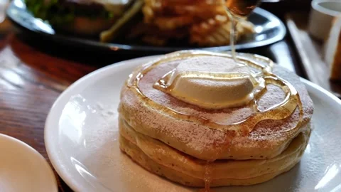 Pouring maple syrup on a stack of fluffy pancakes Stock Footage 328141273