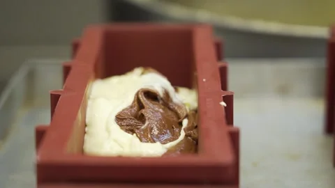 Pouring marble cake batter into loaf pan for baking, Closeup Video stock 251862357