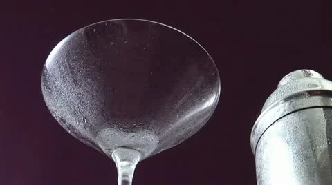 Pouring Martini from cocktail shaker into chilled glass Vídeos de archivo 24633700