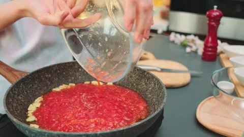 Pouring mashed tomatoes into the pan Stock Footage 252371085