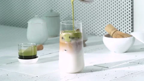 Pouring Matcha into Coffee and Milk Glass Stock Footage 334697992