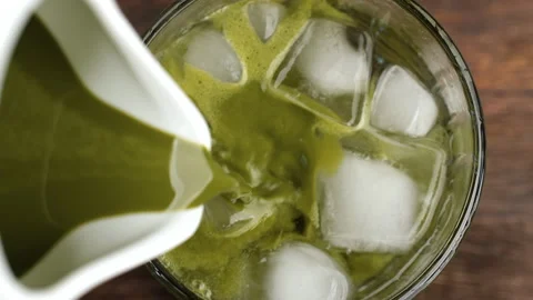 Pouring matcha tea in glass with sparkling water and ice cubes Stock Footage 340190906