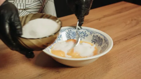 Pouring measured granulated sugar into patterned ceramic plate Vídeos de archivo 330536616