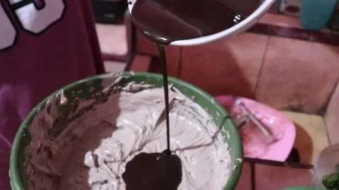Pouring melted chocolate into cake batter Stock Footage 303200753