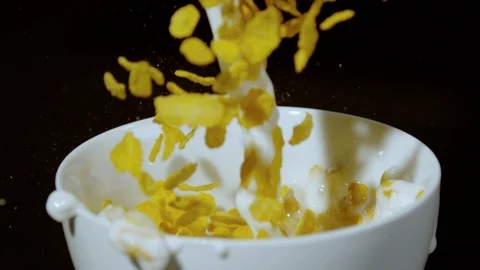 Pouring milk and dropping corn flakes into a bowl, Ultra Slow Motion Video stock 86577643
