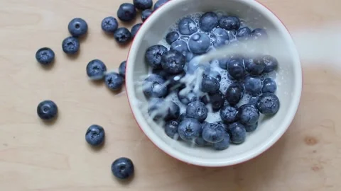 Pouring milk onto blueberries in motion Stock Footage 161105795
