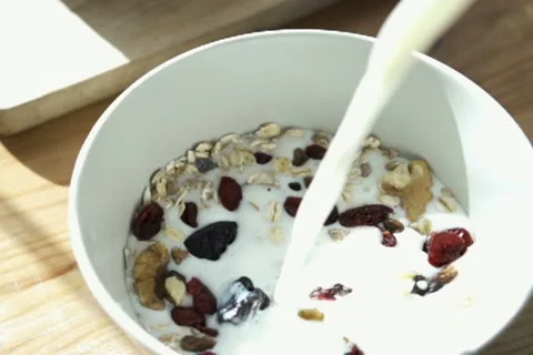 Pouring milk into bowl with muesli NTSC Stock Footage