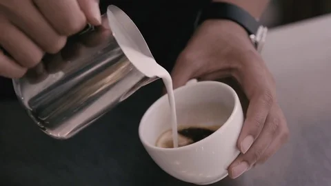 Pouring milk in to coffe Stock Footage 78033673