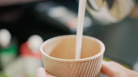 Pouring milk into a coffee cup Video stock 106329575
