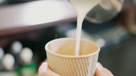 Pouring milk into a coffee cup Stock Footage 106329580