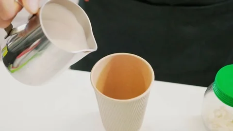 Pouring milk into a coffee cup Stock Footage 106329592