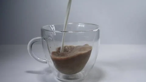 Pouring milk into a coffee cup Stock Footage 243954099