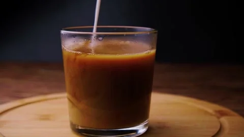 Pouring milk into a coffee drink. Stock Footage 242265070
