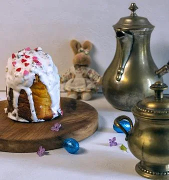 Pouring milk into coffee with Easter cake and plush bunny on background. Stock Photos